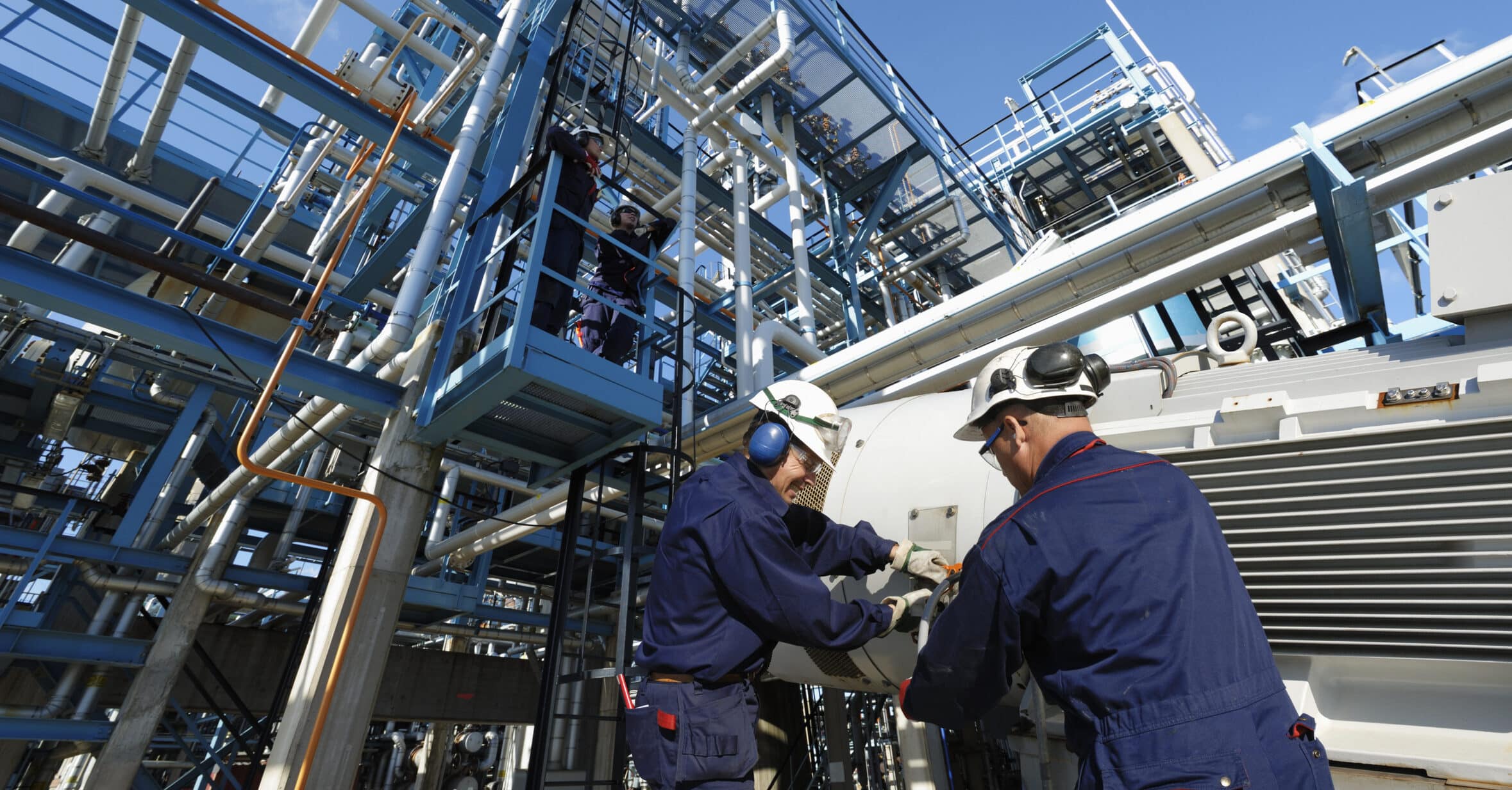 Arbeiter in der Chemischen Industrie vor Rohrleitungen